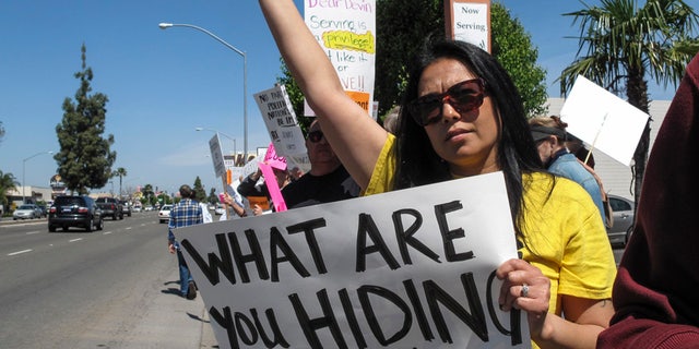 Protesters held signs as Rep. Devin Nunes visited Fresno, Calif., in March 2017.