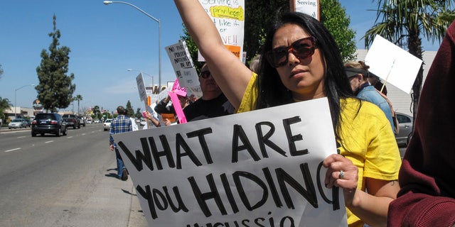 Protesters held signs as Rep. Devin Nunes visited Fresno, Calif., in March 2017.