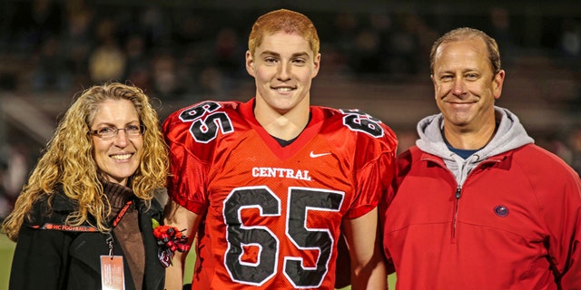 Timothy Piazza, center, is seen with his parents Evelyn and James Piazza, during his high school football team's Senior Night, in Flemington, N.J., Oct. 31, 2014.