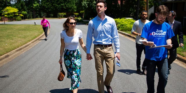 Jon Ossoff, center, a 30-year-old Democrat running for Congress in Georgia's traditionally conservative 6th Congressional District, and fiancee Alisha Kramer, left, walk with organizer Eliot Beckham, right, while campaigning in Sandy Springs, Ga., Thursday, May 11, 2017. Ossoff's fortunes in a June 20 matchup with Republican Karen Handel will be an early test of how the Republicans' vote to gut the Affordable Care Act and President Donald Trump's decision to fire the FBI director are playing with voters. Both parties see the Georgia race as an indicator for the 2018 midterm elections. (AP Photo/David Goldman)