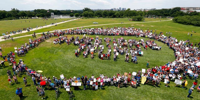 Protesters form letters that spell "Impeach Trump" at a rally to protest President Trump and his policies on the National Mall June 3.