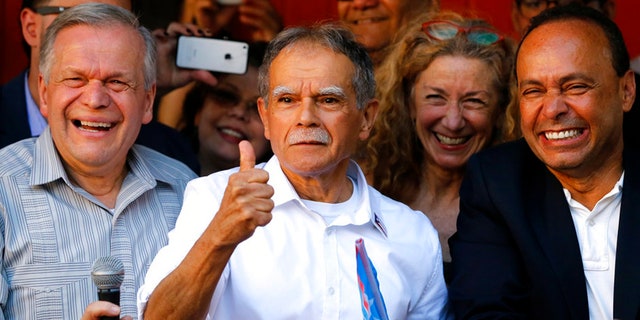 FILE- In this May 18, 2017 file photo, Puerto Rican nationalist Oscar Lopez Rivera, center, reacts to the crowd as his brother Jose, left, and U.S. Rep Luis Gutierrez, D-Ill., join him at a gathering in his honor in Chicago's Humboldt Park neighborhood. New York City's annual Puerto Rican Day parade will take place under a cloud of controversy this year because of a decision by organizers to honor Lopez Rivera, who spent decades in prison because of his involvement with the terrorist group FALN. (AP Photo/Charles Rex Arbogast, File)