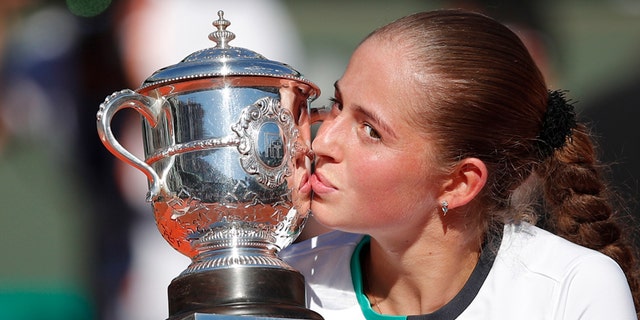 Latvia's Jelena Ostapenko kisses the trophy after winning the women's final match of the French Open tennis tournament against Romania's Simona Halep in three sets 4-6, 6-4, 6-3, at the Roland Garros stadium, in Paris, France, Saturday, June 10, 2017. (AP Photo/Christophe Ena)
