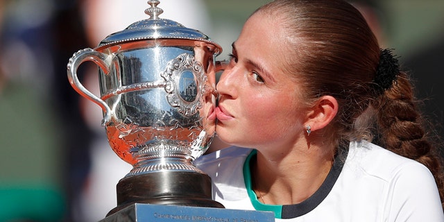 Latvia's Jelena Ostapenko kisses the trophy after winning the women's final match of the French Open tennis tournament against Romania's Simona Halep in three sets 4-6, 6-4, 6-3, at the Roland Garros stadium, in Paris, France, Saturday, June 10, 2017. (AP Photo/Christophe Ena)