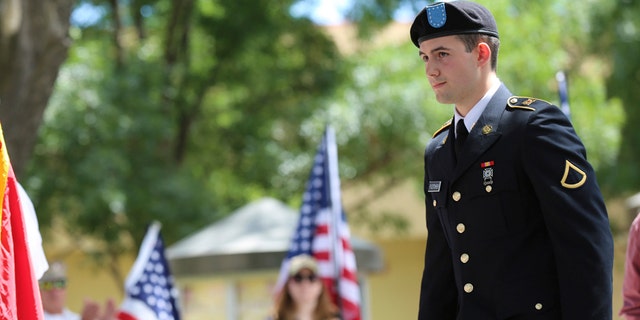Army reservist Harland Fletcher walks on stage to receive his high school diploma during a private graduation ceremony Monday in Brentwood, Calif.