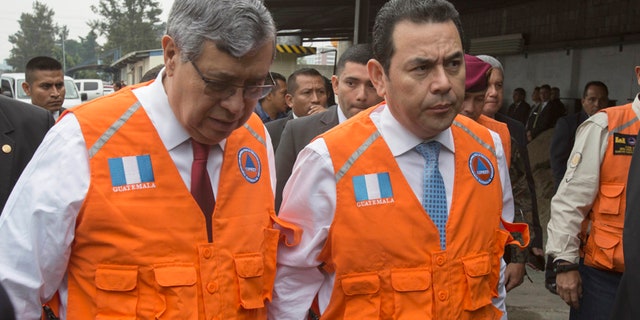 Guatemala's President Jimmy Morales, right, accompanied by his Vice-President Jafeth Cabrera talk as they arrive to National Emergency Coordination Agency's headquarters in Guatemala City, Wednesday, June 14, 2017. Morales says two people died in a magnitude 6.9 earthquake in western Guatemala near the border with Mexico on Wednesday. (AP Photo/Moises Castillo)