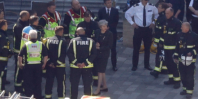 Britain's Prime Minister Theresa May arrives at Grenfield Tower in London, Thursday, June 15, 2017, following a deadly fire in the apartment block.