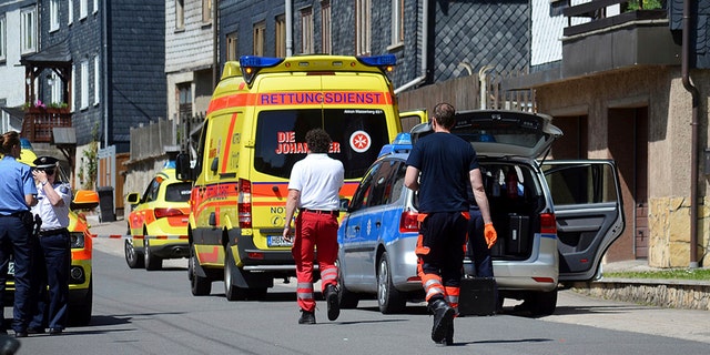 The emergency services and police stand outside a house after a family incident in Altenfeld, Germany, Thursday, June 15, 2017. Authorities in Germany say a man has stabbed two of his children to death and seriously injured another in the eastern state of Thuringia. (WichmannTV/dpa via AP)
