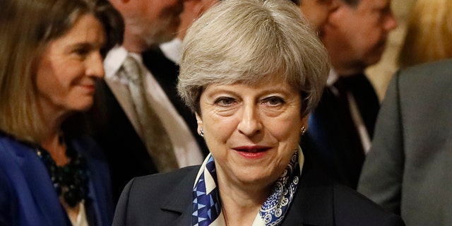 Britain's Prime Minister Theresa May walks through the House of Commons to attend the state opening of Parliament in London, Wednesday, June 21, 2017. Queen Elizabeth II goes to parliament Wednesday to outline the government's legislative program with far less pageantry than usual in a speech expected to be dominated by Britain's plans for leaving the European Union.(AP Photo/Kirsty Wigglesworth, pool)