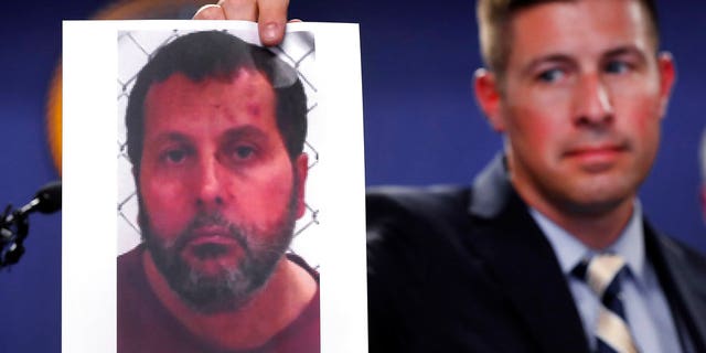 Timothy Wiley, FBI public affairs specialist, holds a photo Amor Ftouhi after a news conference in Detroit, Thursday, June 22, 2017. Amor Ftouhi, a Canadian man, shouted in Arabic before stabbing a police officer in the neck at the Bishop International Airport in Flint, Mich., on Wednesday, and referenced people being killed overseas during the attack that's now being investigated as an act of terrorism, federal officials said. (AP Photo/Paul Sancya)
