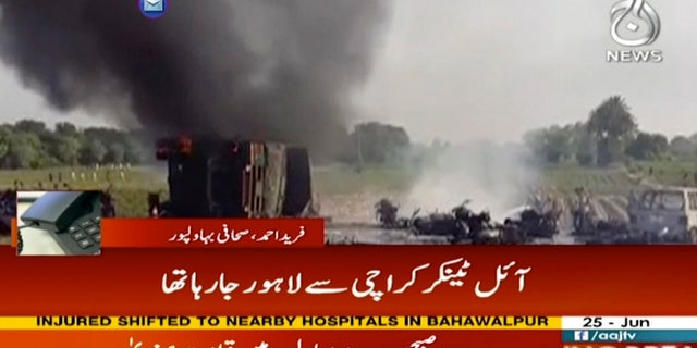 In this image taken from video, black smoke rises from oil tanker on road in Bahawalpur, Pakistan, Sunday, June 25, 2017. An overturned oil tanker burst into flames in Pakistan on Sunday, killing people who had rushed to the scene of the highway accident to gather leaking fuel, an official said. (AAJ News via AP Video)