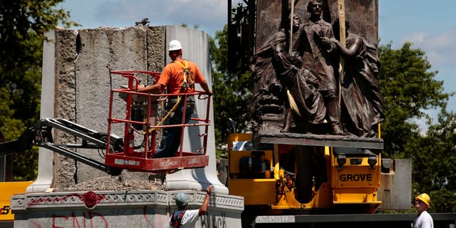 A crane removes a sculpture from a Confederate monument in Forest Park on Monday, June 26, 2017, in St. Louis. Crews on Monday began dismantling the divisive monument after the city and the Missouri Civil War Museum reached an agreement to have it moved. (Robert Cohen /St. Louis Post-Dispatch via AP)