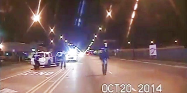 In this Oct. 20, 2014 file image taken from dash-cam video provided by the Chicago Police Department, Laquan McDonald, right, walks down the street moments before being fatally shot by Chicago Police officer Jason Van Dyke in Chicago.