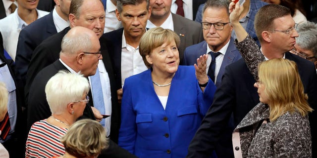 German Chancellor Angela Merkel, center, gestures as a lawmaker raising a "No"-polling card during a meeting of the German Federal Parliament, Bundestag, at the Reichstag building on same-sex marriage in Berlin, Germany, Friday, June 30, 2017. (AP Photo/Michael Sohn)