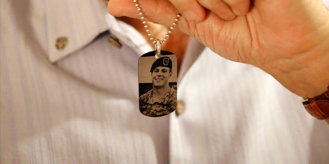 June 17: Brian McEnroe displays a memorial dog tag depicting his fallen son.