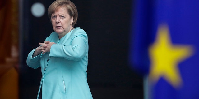 German Chancellor Angela Merkel stands behind a European flag as she waits for the arrival of Chinese President Xi Jinping at the chancellery in Berlin, Germany, Wednesday, July 5, 2017. Xi is in Germany to open an Panda enclosure in Berlin and to attend the G-20 summit in Hamburg later the week. (AP Photo/Markus Schreiber)
