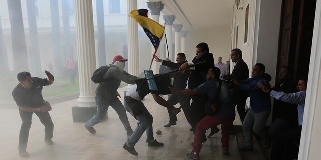 Opposition lawmakers brawl with pro-government militias who are trying to force their way into the National Assembly during a special session coinciding with Venezuela's independence day, in Caracas, Wednesday, July 5, 2017.