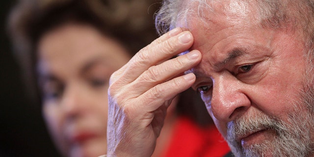 FILE - In this July 5, 2017 file photo, Brazil's Former President Luiz Inacio Lula da Silva attends the inauguration ceremony for the new leadership of the Workers' Party, with ousted President Dilma Rousseff, behind, in Brasilia, Brazil. A Brazilian federal judge has convicted the former president of corruption and money laundering on Wednesday, July 12, 2017. (AP Photo/Eraldo Peres, File)