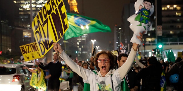 Demonstrators celebrate the decision by Judge Sergio Moro to convict former Brazilian President Luiz Inacio Lula da Silva in Sao Paulo, Brazil, Wednesday, July 12, 2017. Silva was found guilty of corruption and money laundering Wednesday and sentenced to almost 10 years in prison. (AP Photo/Andre Penner)