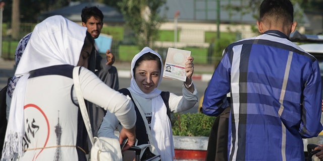 A members of a female robotics team from Herat province, shows her U.S. Visa as she leaves Kabul to the U.S. from Kabul Airport, in Kabul, Afghanistan, Friday, Jun 14, 2017. The third time's the charm for Afghanistan's all girl robotics team, who will be allowed entry into the U.S. to compete in a competition after President Donald Trump personally intervened to reverse a decision twice denying them enter into the country. (AP Photos/Massoud Hossaini)