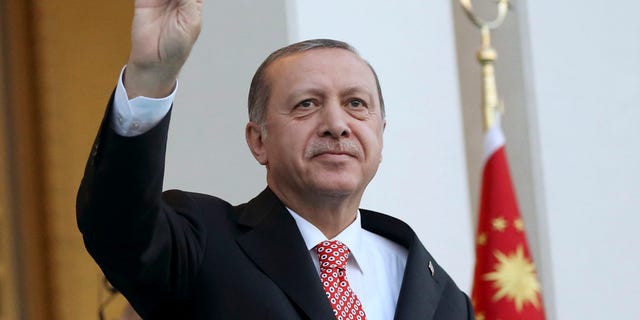 Turkey's President Recep Tayyip Erdogan waves to supporters outside the Presidential Palace.