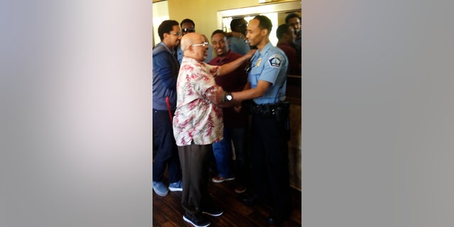 In this May 2016 photo provided by the City of Minneapolis, police Officer Mohamed Noor, right, is greeted by a well-wisher at a community event welcoming him to the Minneapolis police force.