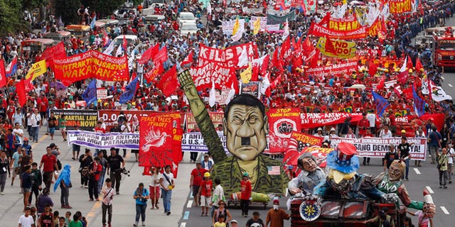 Thousands of protesters march towards the Lower House with an effigy of President Rodrigo Duterte.