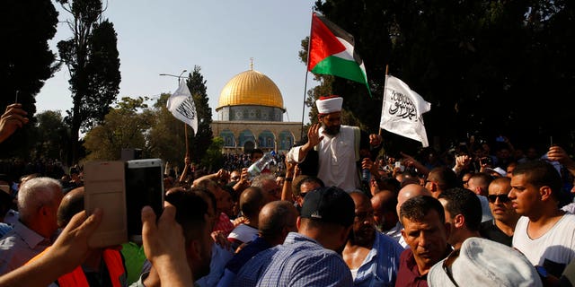 Palestinians and Israeli police officers scuffle.