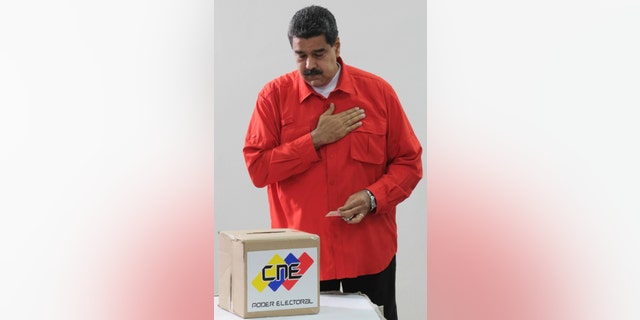 In this photo released by Miraflores Press Office, Venezuela's President Nicolas Maduro gestures after he casts his ballot as he votes for a constitutional assembly in Caracas, Venezuela on Sunday, July 30, 2017.