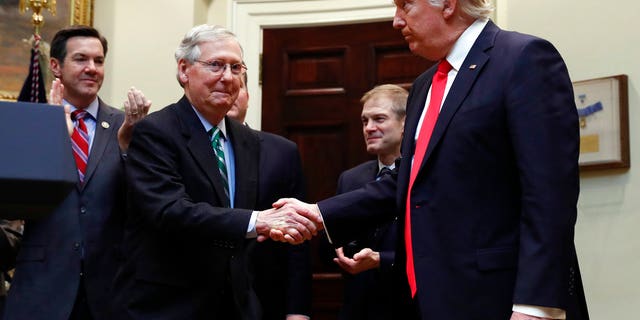 President Donald Trump shakes hands with Senate Majority Leader Mitch McConnell of Kentucky during a ceremony at the White House. The feud between McConnell and Trump has escalated over recent weeks.