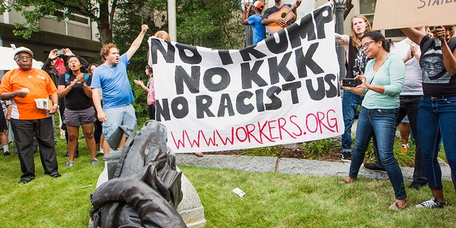 Protesters celebrate after toppling a statue of a Confederate solder in Durham, N.C. Monday, Aug. 14, 2017.