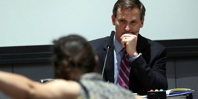 A protester yells as Mayor Mike Signer listens during the Charlottesville City Council.