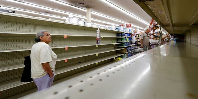 Shoppers pass empty shelves in a Houston grocery store as Hurricane Harvey intensifies.