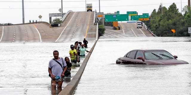 Evacuees on a flooded section of Interstate 610 in Houston, Texas.