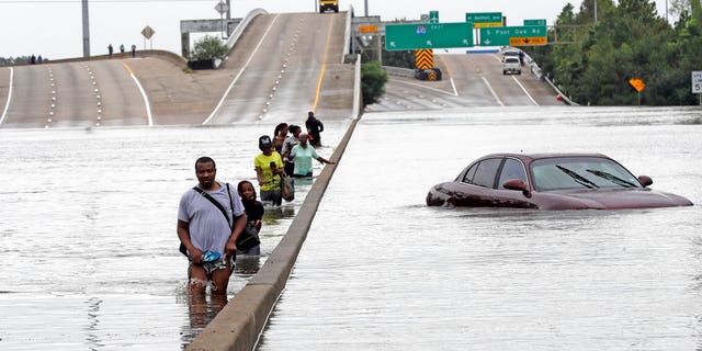Evacuees on a flooded section of Interstate 610 in Houston, Texas.