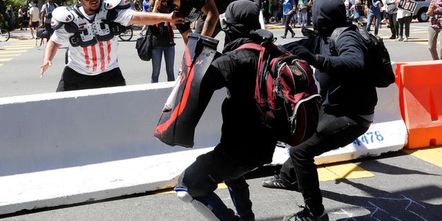 Demonstrator Joey Gibson, second from left, is chased by anti-fascists during a free speech rally on Aug. 27.