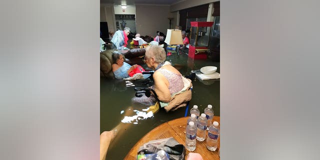 Residents of the La Vita Bella nursing home in Dickinson, Texas, sit in waist-deep flood waters caused by Hurricane Harvey. (Trudy Lampson via AP)
