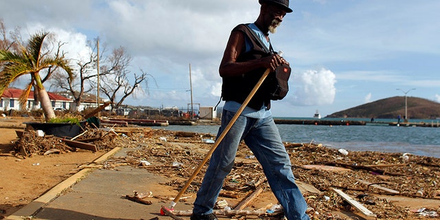 A man walks past debris caused by Hurricane Irma in Charlotte Amalie, St. Thomas, U.S. Virgin Islands, Sunday, Sept. 10, 2017. The storm ravaged such lush resort islands as St. Martin, St. Barts, St. Thomas, Barbuda and Anguilla. (AP Photo/Ricardo Arduengo)
