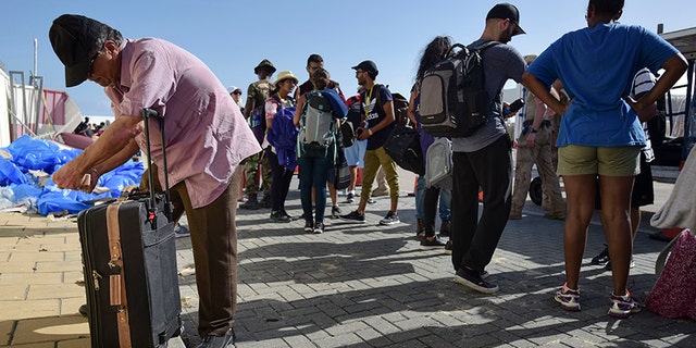 People wait in line while U.S. Air force units prepare to evacuate several hundreds of American citizens from Princes Juliana International Airport.