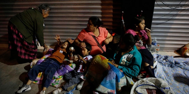 Families fearing aftershocks prepare to sleep on the street in the Roma neighborhood of Mexico City on Tuesday.
