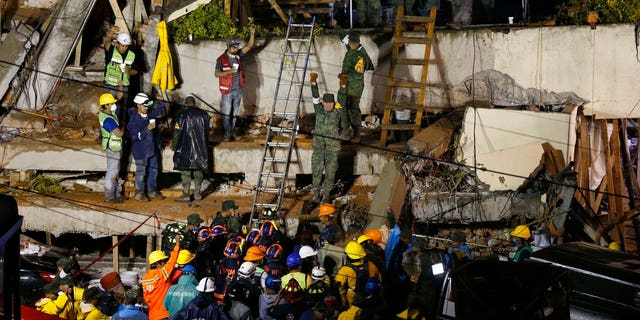 Rescue personnel work on the rescue of a trapped child at the collapsed Enrique Rebsamen primary schoool in Mexico City.
