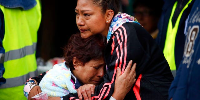 A family hug as they wait to hear for more survivors buried under the rubble.