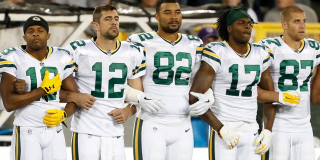 Green Bay Packers link arms during the national anthem before an NFL football game against the Chicago Bears Thursday, Sept. 28, 2017, in Green Bay, Wis. (AP Photo/Matt Ludtke)