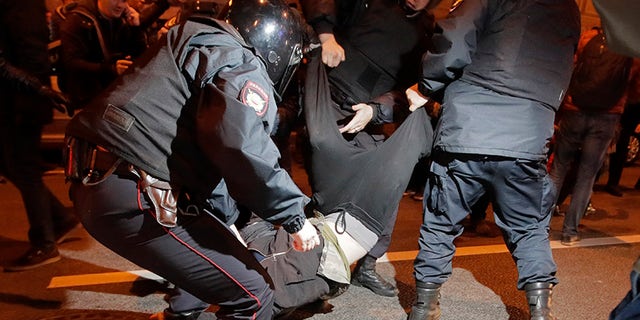 Riot police officers detain a protester during a rally in St.Petersburg, Russia, Saturday, Oct. 7, 2017. Supporters of opposition leader Alexei Navalny rallied across Russia on Saturday, heeding his call to pressure authorities into letting him enter the presidential race with a wave of demonstrations on President Vladimir Putin's 65th birthday. (AP Photo/Dmitri Lovetsky)
