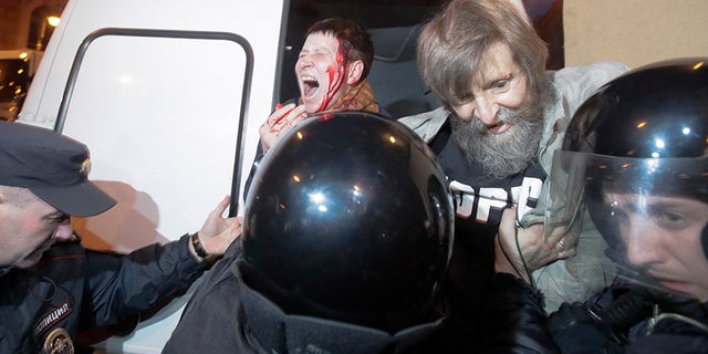 Riot police officers detain protesters during a rally in St.Petersburg, Russia, Saturday, Oct. 7, 2017. Supporters of opposition leader Alexei Navalny rallied across Russia on Saturday, heeding his call to pressure authorities into letting him enter the presidential race with a wave of demonstrations on President Vladimir Putin's 65th birthday. (AP Photo/Dmitri Lovetsky)