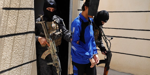 FILE - In this file picture taken on Friday, July 21, 2017, Kurdish soldiers from the Anti-Terrorism Units, carry a blindfolded an Indonesian man suspected of Islamic State membership, at a security center, in Kobani, Syria. Western governments have tacitly handed down guidance to the forces uprooting the remnants of Islamic State in Raqqa and beyond on how to handle their citizens who joined the extremist group by the thousands. (AP Photo/Hussein Malla, File)