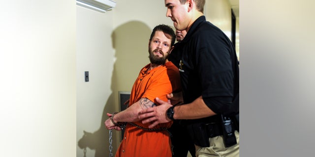 Oberhansley, shown being escorted through the Clark County Courthouse in 2015, has had previous outbursts in court and said his name was Zeus.