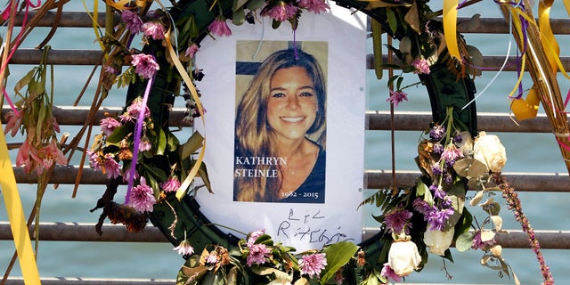 This July 17, 2015, file photo shows flowers and a portrait of Kate Steinle displayed at a memorial site on Pier 14 in San Francisco, Calif. The bullet that killed Kate Steinle ago ricocheted off the ground about 100 yards away before hitting her in the back and later launching a criminal case at the center of a national immigration debate.