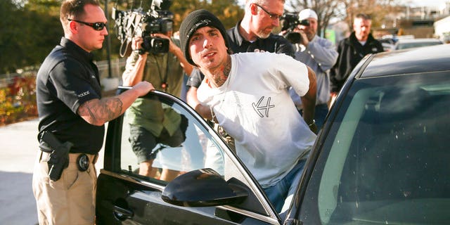 Austin Boutain, a suspect in Monday night's fatal shooting of University of Utah student ChenWei Guo, is led out of the University of Utah Department of Public Safety in Salt Lake City on Tuesday.