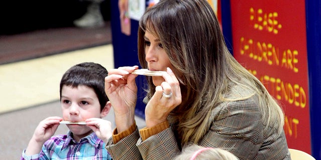 First lady Melania Trump plays a harmonica she made out of household items at Joint Base Elmendorf-Richardson, Alaska.